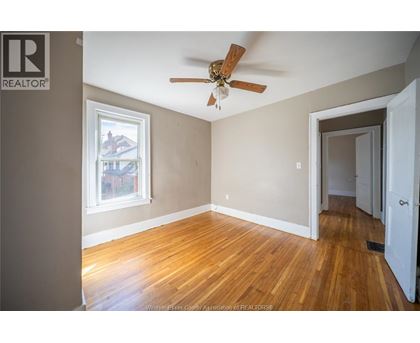 A room with a ceiling fan and a window.
