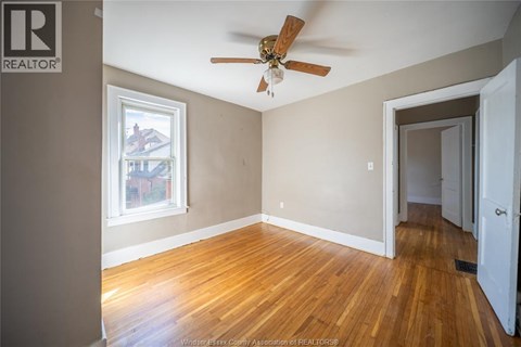 A room with a ceiling fan and a window.
