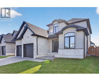 A large, modern house with a stone exterior and a dark grey roof.