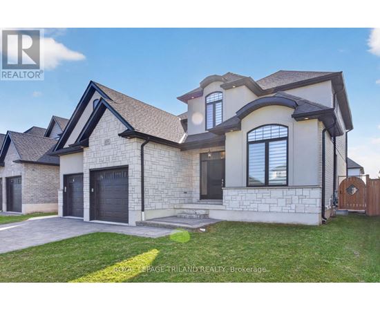A large, modern house with a stone exterior and a dark grey roof.