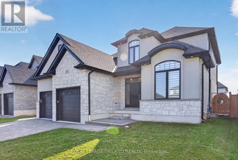A large, modern house with a stone exterior and a dark grey roof.