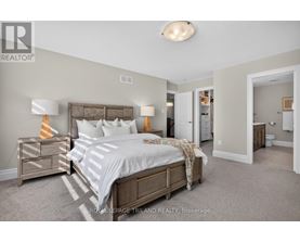 A bedroom with a bed, nightstand, and lamp.