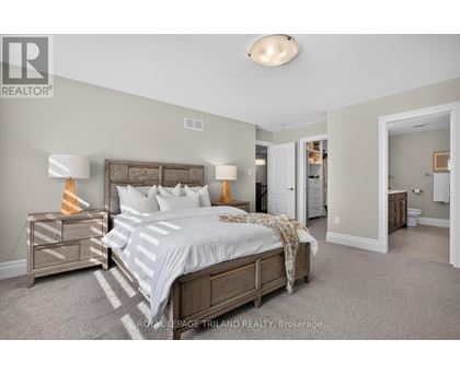 A bedroom with a bed, nightstand, and lamp.
