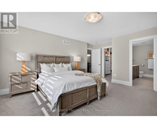 A bedroom with a bed, nightstand, and lamp.