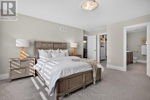 A bedroom with a bed, nightstand, and lamp.