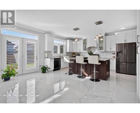 A modern kitchen with white cabinets and a marble floor.