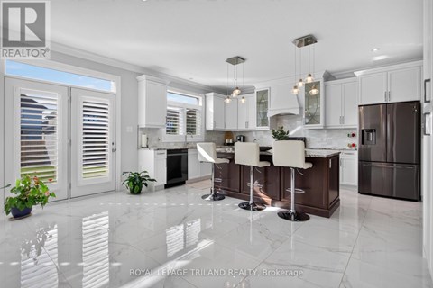 A modern kitchen with white cabinets and a marble floor.