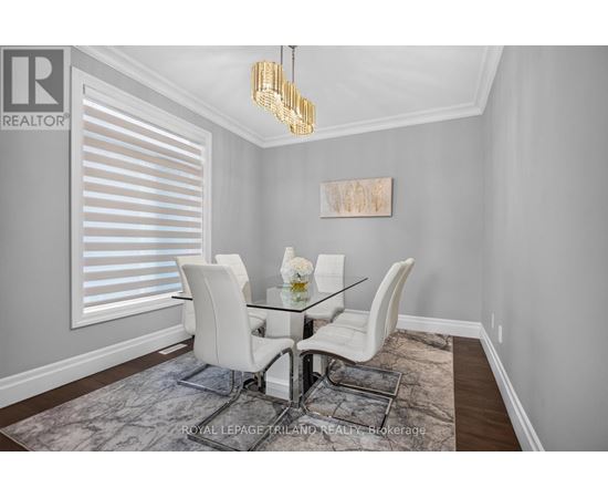 A dining room with a glass table and white chairs.