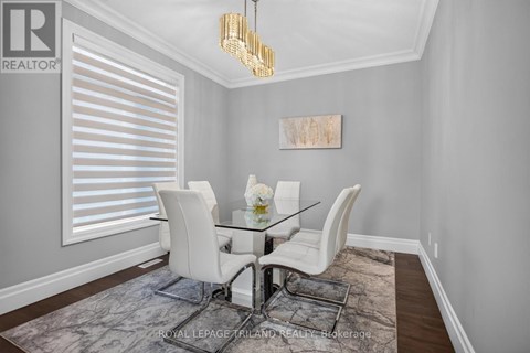 A dining room with a glass table and white chairs.