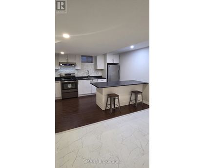 A kitchen with a white marble counter top and a black stove.