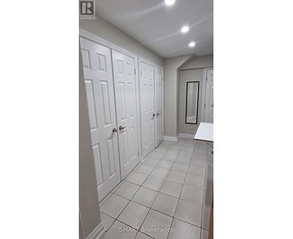 A hallway with white doors and tiled floors.