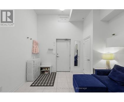 A bedroom with a blue bed and a white wall.