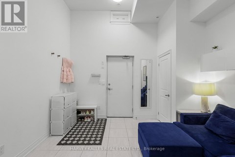 A bedroom with a blue bed and a white wall.