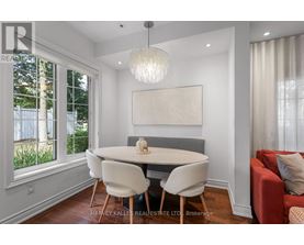 A dining room with a white table and chairs.