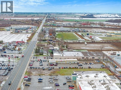 A realtor company logo is displayed on a picture of a parking lot and buildings.