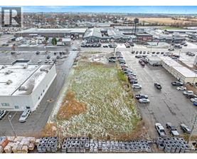 A parking lot with cars and trucks is surrounded by buildings.