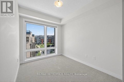 A room with a large window and a view of buildings outside.