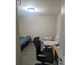 A bedroom with a bed, chair, and desk.