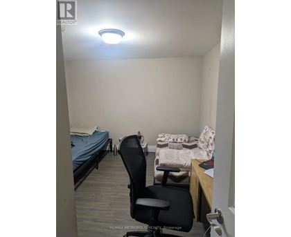 A bedroom with a bed, chair, and desk.