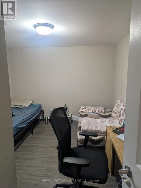 A bedroom with a bed, chair, and desk.