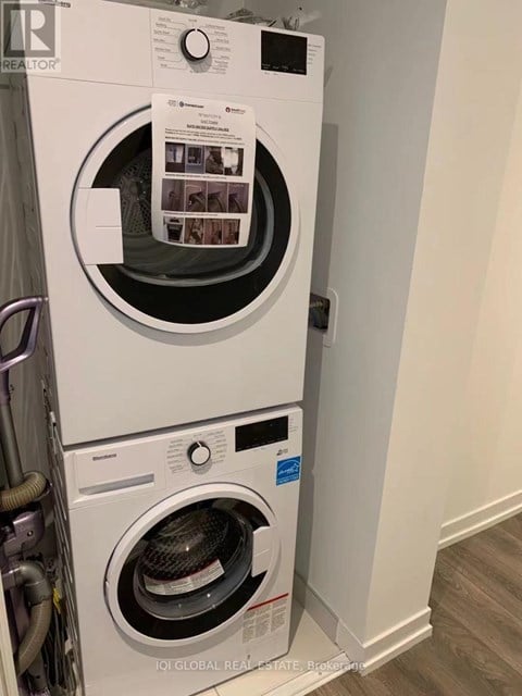 A white front load washing machine with a black door and a control panel on the front.