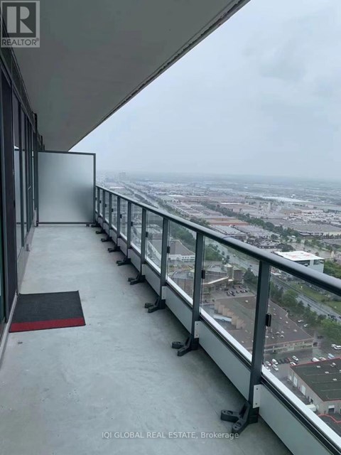 A balcony with a glass railing overlooking a cityscape.