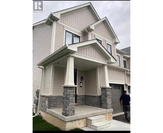 A house with a grey and white exterior and a stone pillar on the front porch.