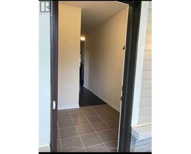 A hallway with a tile floor and white walls.