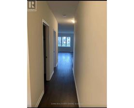 A long hallway with a door on the left and a window on the right.