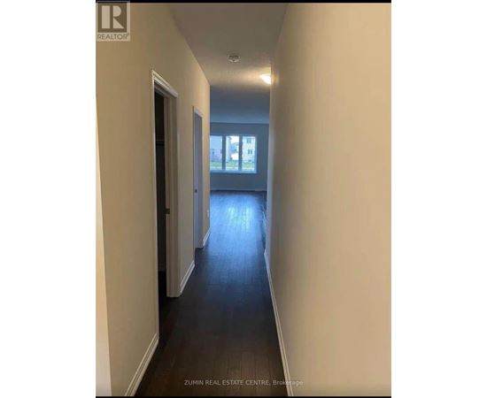 A long hallway with a door on the left and a window on the right.
