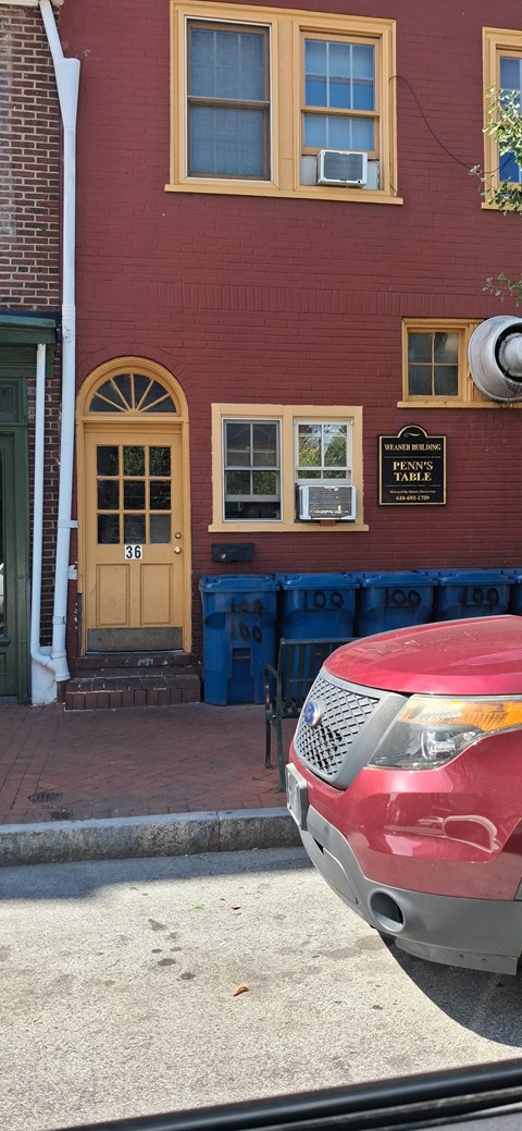 A red building with a sign that says "The corner store".