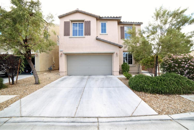 A house with a grey garage door in front.
