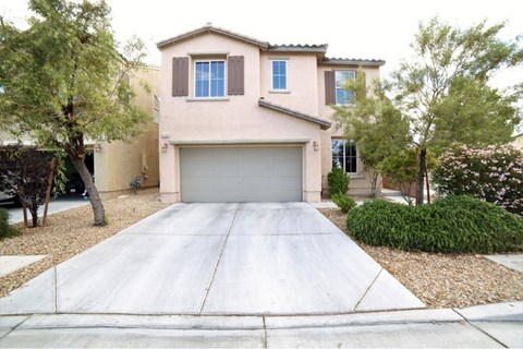 A house with a grey garage door in front.