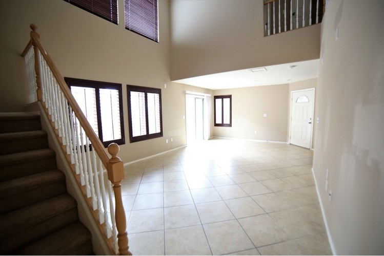 A spacious living room with a staircase leading to the upper floor.