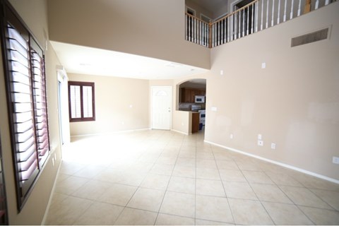 A spacious room with a window on the left side and a door on the right side.
