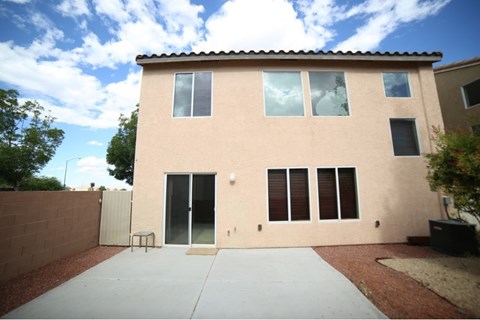 A house with a tan exterior and a grey roof.