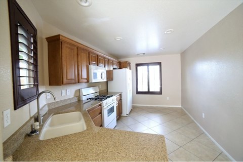 A kitchen with brown cabinets and a white refrigerator.