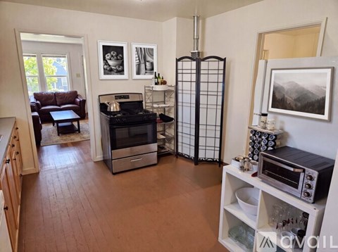 A kitchen with a refrigerator, oven, and a microwave.