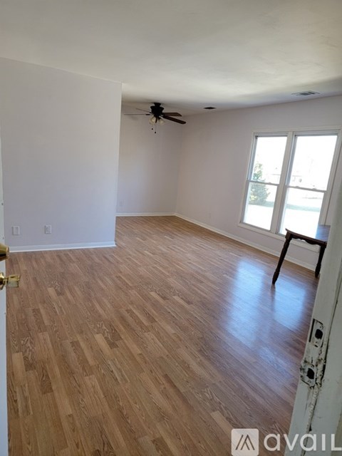 A room with wooden flooring and a ceiling fan.