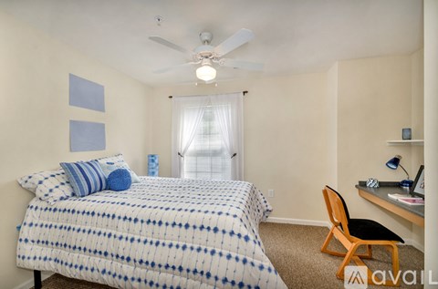 A bedroom with a bed, desk, and chair.