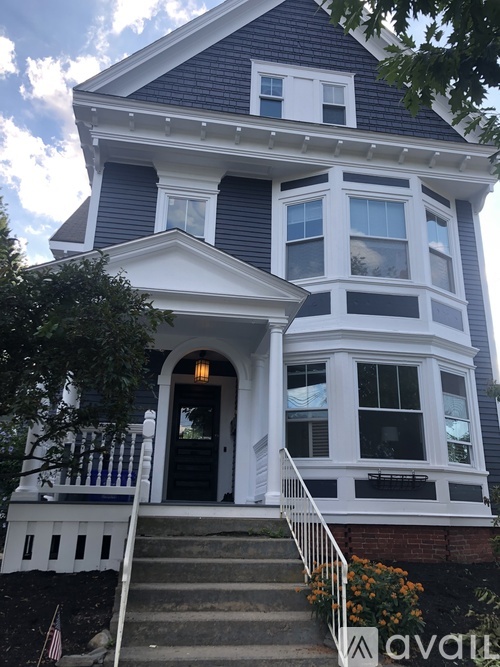 A two-story house with a black front door and white trim.