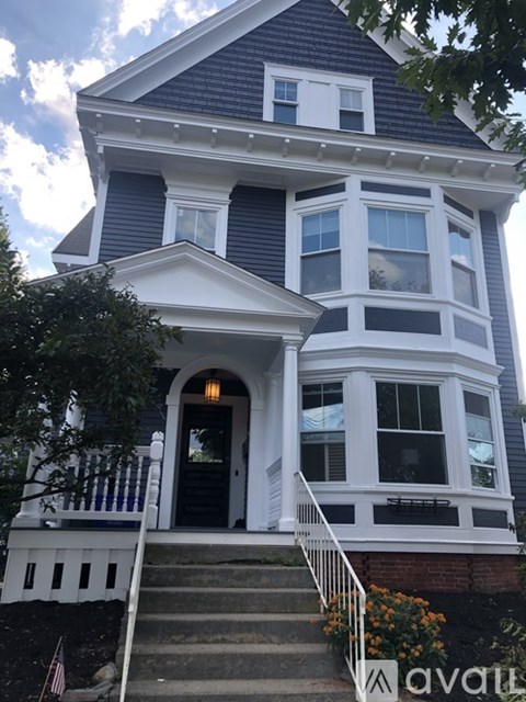 A two-story house with a black front door and white trim.