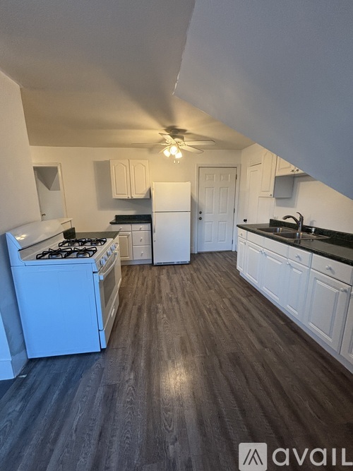 A kitchen with white cabinets and a black stove top.