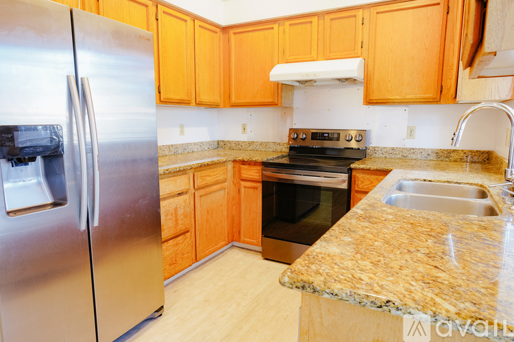 A kitchen with wooden cabinets and a granite countertop.