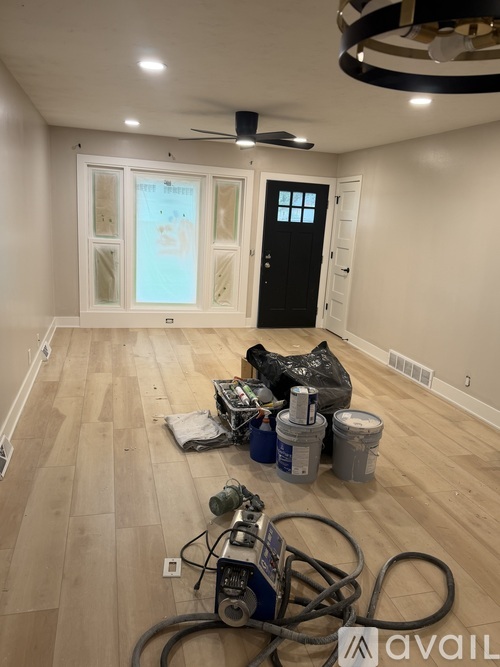 A room with a black door and a fan on the ceiling.