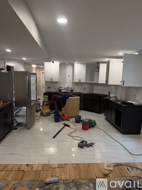 A kitchen undergoing renovation with tools and materials scattered around.