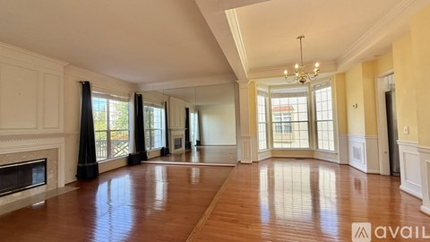 A spacious room with hardwood floors and a fireplace is available for rent.