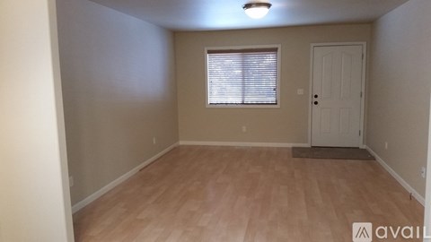 A room with wooden flooring and a white door.