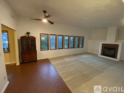 A room with a fireplace and a fan on the ceiling.