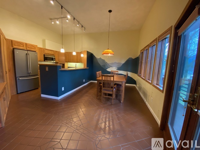 A kitchen with a dining table and chairs.